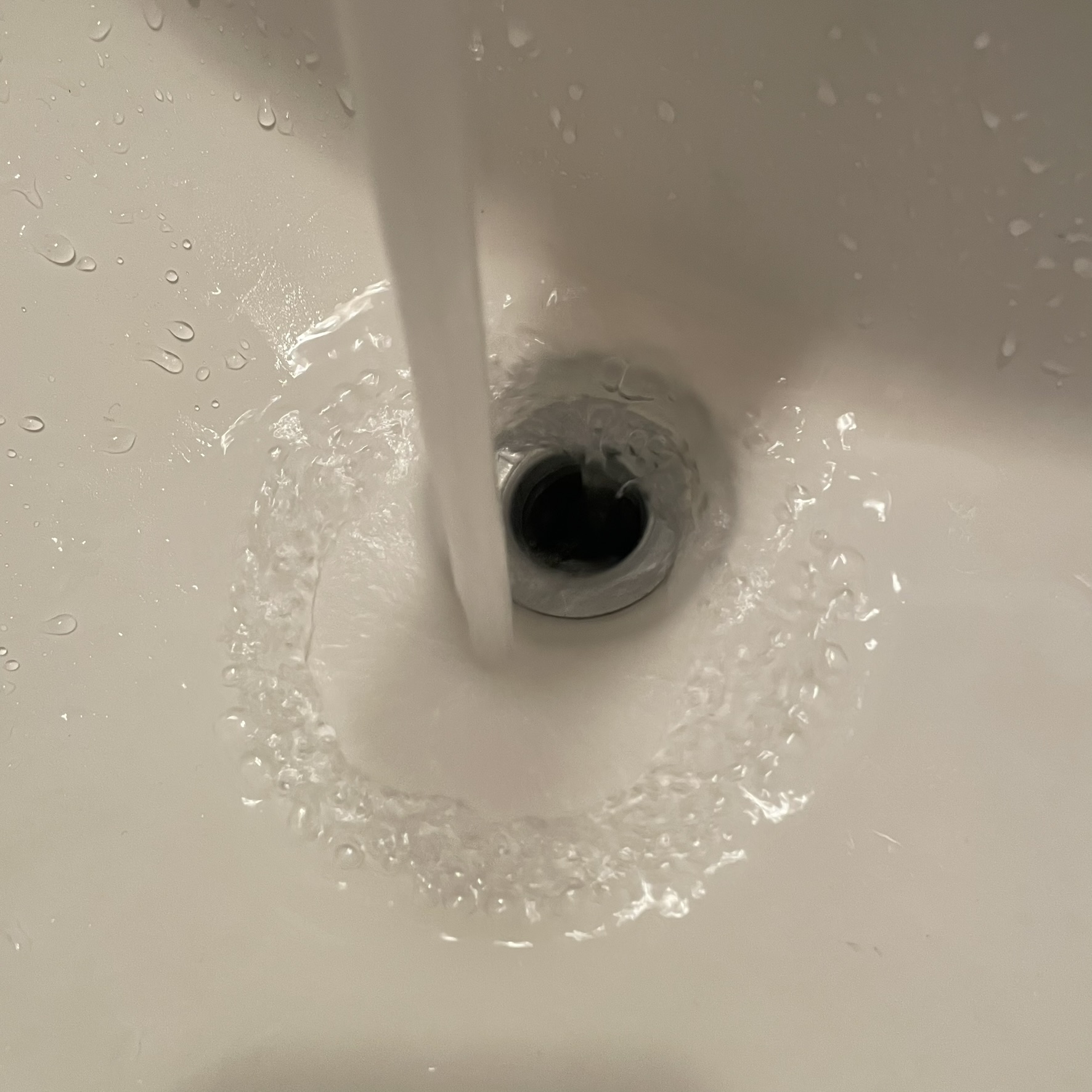 This is a sink drain with the sound of water being poured out of a cup going down the drain
